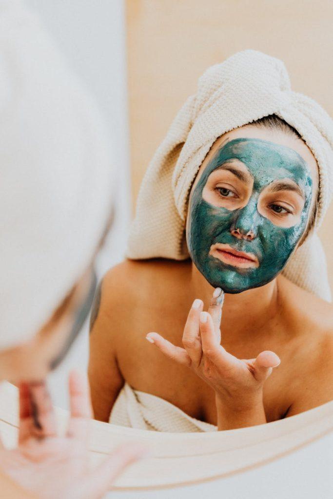 Woman applying a homemade face mask during a year of DIY beauty treatments.