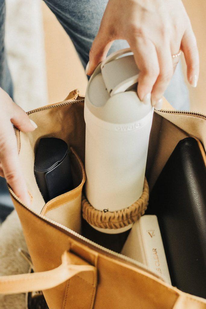 Woman efficiently packing a carry-on bag for travel.
